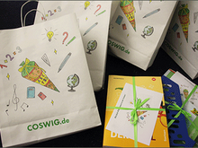 Papiertüten mit Schulmotiven und Coswiger Schriftzug, Schulbücher und Schreibmaterial für die Erstklässler