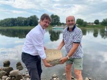 v. l.: Olaf Lier, Leiter des Fachbereichs Ordnungswesen, und Steffen Spindler, ehemaliger Lehrer, heben den Hungerstein in die Elbe.
