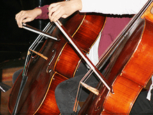 zwei Musikschüler spielen Cello