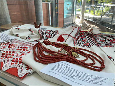 Vitrine mit persönlichen Ausstellungsstücken von Geflüchteten wie Schmuck und Kleidung.