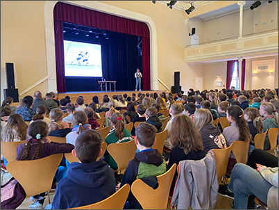 Viele Kinder sitzen in der Börse beim Welttag des Buches.